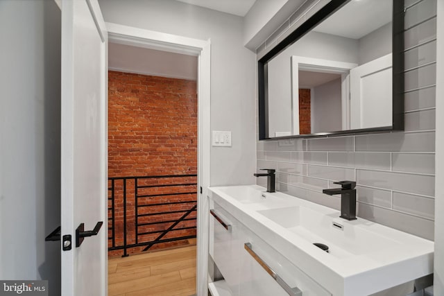 bathroom with vanity, hardwood / wood-style floors, and decorative backsplash