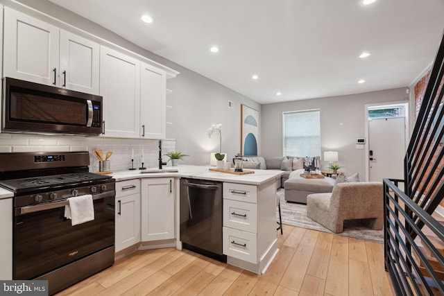 kitchen featuring light wood-type flooring, appliances with stainless steel finishes, and white cabinetry