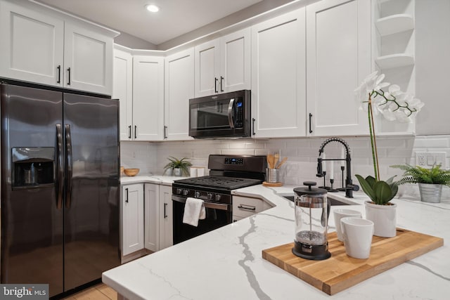 kitchen featuring black appliances, light stone countertops, and white cabinets