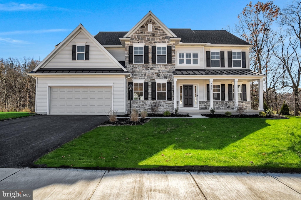 view of front facade featuring a front lawn, covered porch, and a garage