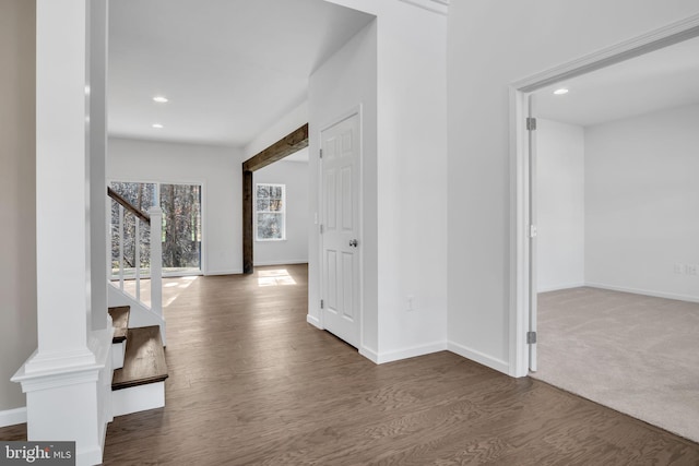 hallway featuring ornate columns and dark hardwood / wood-style floors