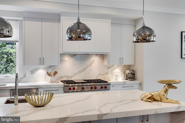 kitchen with decorative backsplash, light stone countertops, white cabinetry, and decorative light fixtures