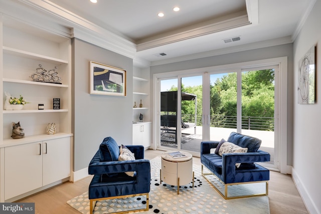 sitting room featuring a wealth of natural light, built in features, light hardwood / wood-style floors, and ornamental molding