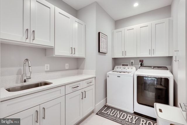 washroom featuring cabinets, separate washer and dryer, and sink