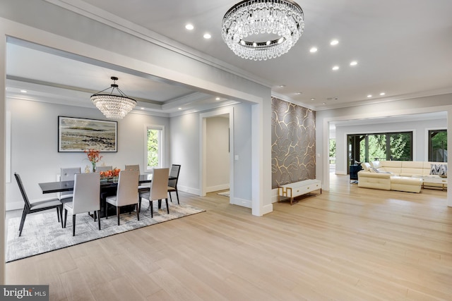 dining area featuring light wood-type flooring, crown molding, and a notable chandelier