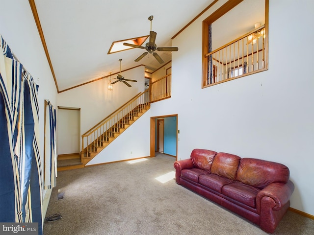 carpeted living room featuring crown molding, ceiling fan, and high vaulted ceiling