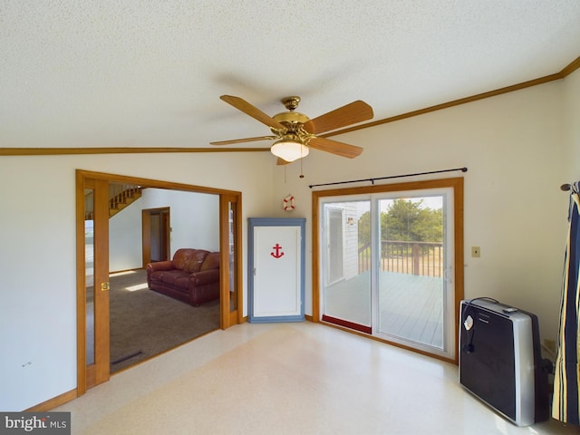 empty room with lofted ceiling, ceiling fan, crown molding, and a textured ceiling