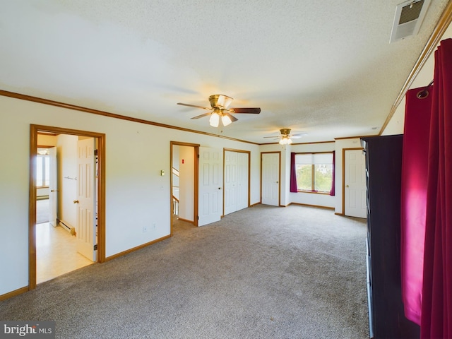 unfurnished bedroom featuring ceiling fan, ornamental molding, and light carpet