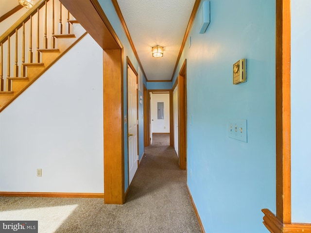 corridor with ornamental molding, carpet floors, and a textured ceiling