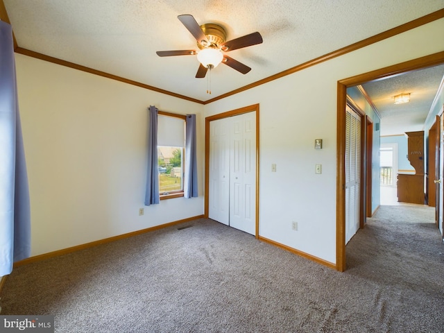 unfurnished bedroom with multiple windows, ornamental molding, ceiling fan, and carpet flooring