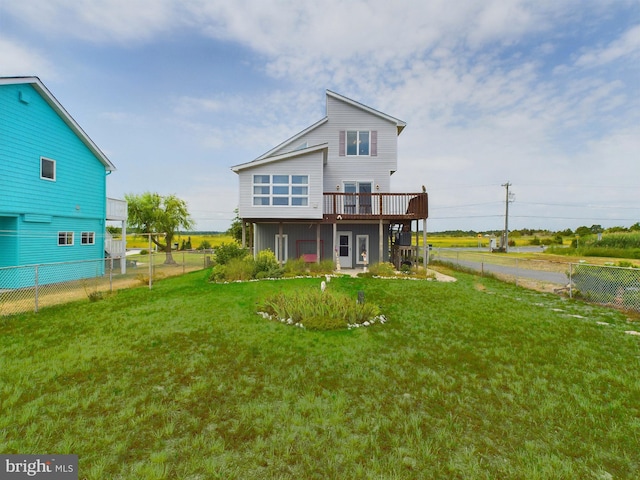 rear view of house with a wooden deck and a yard