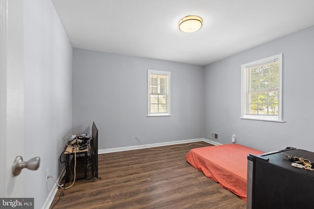 bedroom with dark hardwood / wood-style flooring