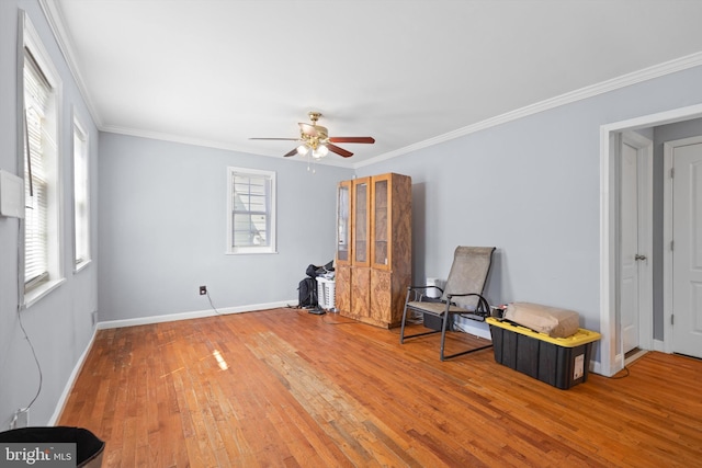 sitting room with hardwood / wood-style flooring, ceiling fan, and ornamental molding