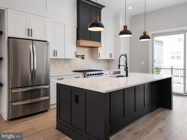 kitchen featuring white cabinetry, sink, hanging light fixtures, and appliances with stainless steel finishes