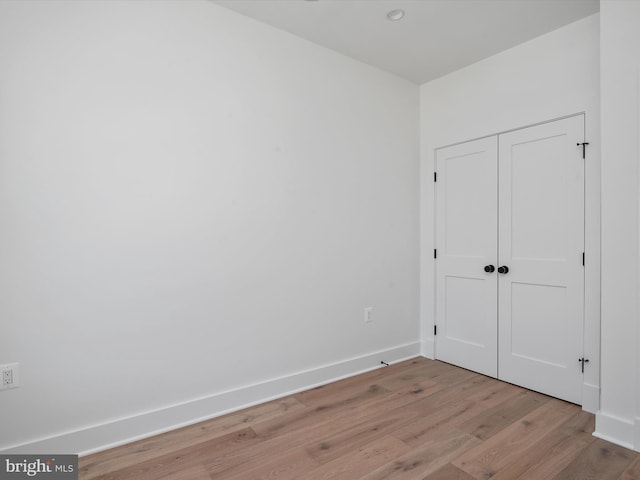 unfurnished bedroom with light hardwood / wood-style floors and a closet