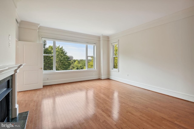 unfurnished living room with ornamental molding and light wood-type flooring