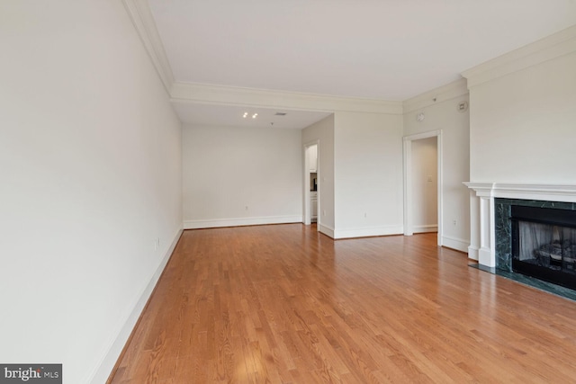 unfurnished living room with ornamental molding, hardwood / wood-style floors, and a fireplace