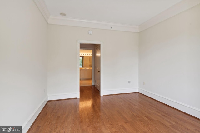 unfurnished room with wood-type flooring and ornamental molding