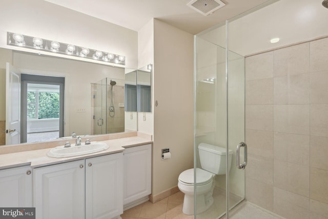 bathroom with tile patterned floors, toilet, a shower with shower door, and vanity