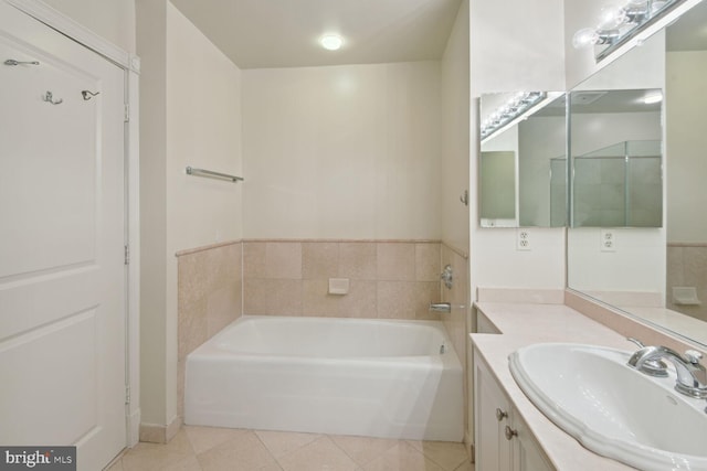 bathroom with tile patterned floors, a bathtub, and vanity