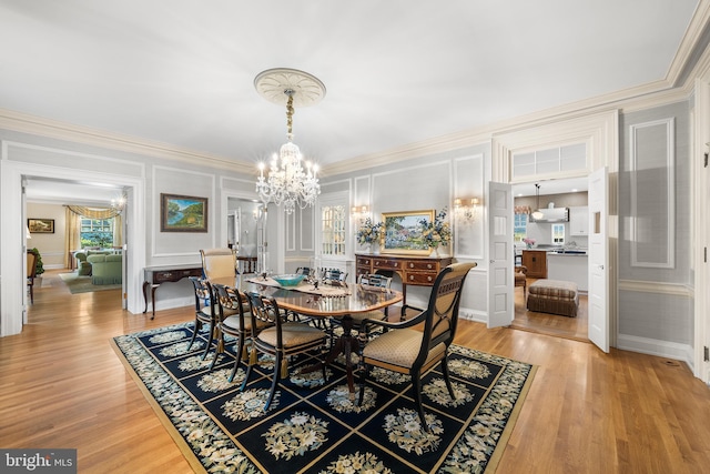 dining room featuring hardwood / wood-style flooring, crown molding, and an inviting chandelier