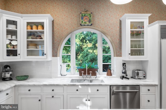 bar with white cabinetry, sink, stainless steel dishwasher, and light stone counters