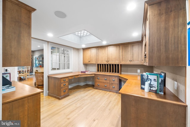 office area featuring built in desk and light hardwood / wood-style flooring