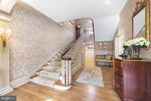 staircase featuring hardwood / wood-style flooring and ornamental molding