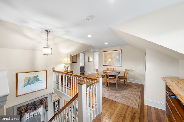 corridor featuring hardwood / wood-style flooring and lofted ceiling