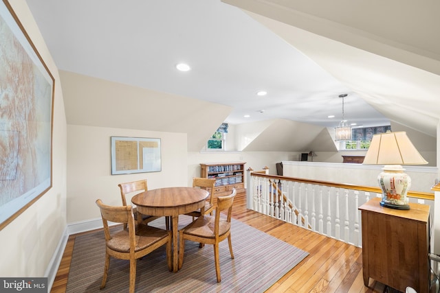 dining space featuring lofted ceiling, light hardwood / wood-style flooring, and a healthy amount of sunlight