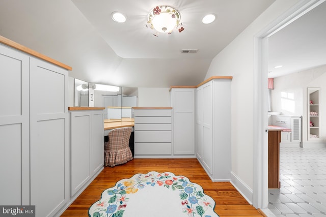 bathroom with wood-type flooring and lofted ceiling