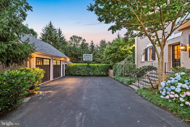 patio terrace at dusk featuring a garage