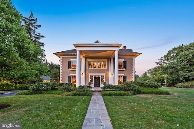 greek revival inspired property with a lawn