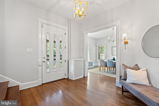 entryway featuring wood-type flooring and a chandelier