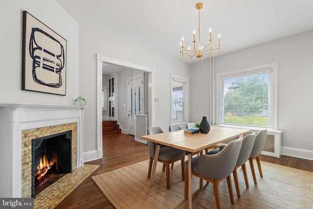 dining area with dark wood-type flooring and an inviting chandelier