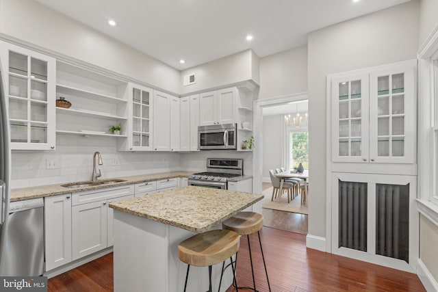 kitchen with white cabinetry, sink, stainless steel appliances, and light stone counters