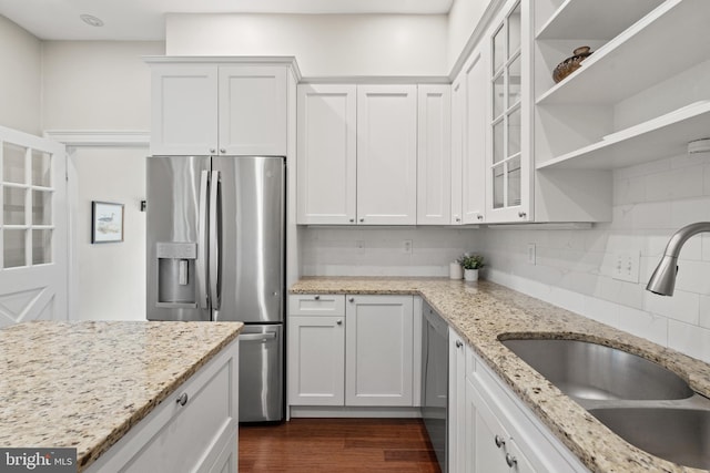 kitchen with white cabinetry, sink, tasteful backsplash, light stone counters, and appliances with stainless steel finishes