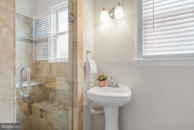 bathroom with a wealth of natural light and a shower with door