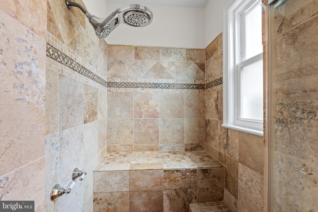 bathroom featuring a tile shower and a wealth of natural light