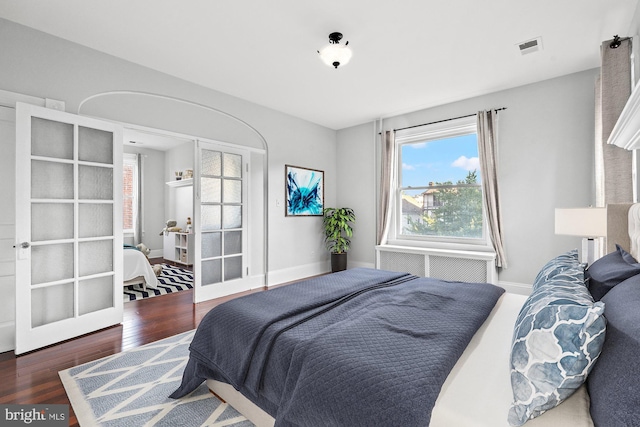 bedroom featuring french doors and dark hardwood / wood-style flooring