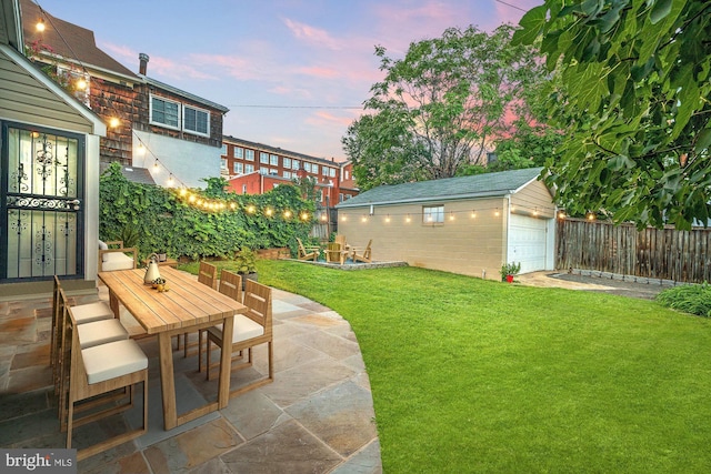 yard at dusk with a patio area, an outdoor structure, and a garage