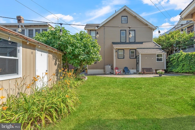 rear view of property featuring a patio area and a lawn