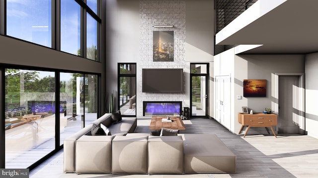 living room featuring a stone fireplace and a towering ceiling