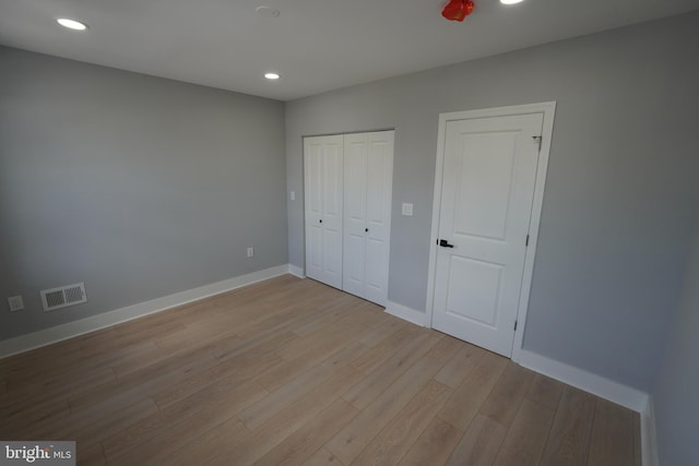 unfurnished bedroom with a closet and light wood-type flooring