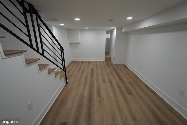 basement with light hardwood / wood-style flooring