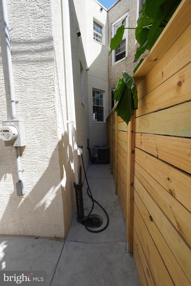 view of side of property with central AC unit and a patio