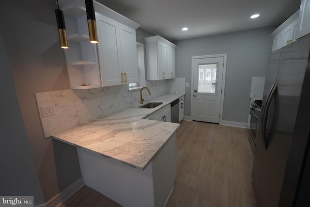 kitchen featuring stainless steel appliances, sink, white cabinets, and kitchen peninsula