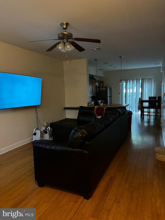 living room featuring ceiling fan and wood-type flooring