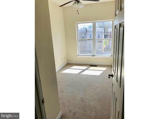 unfurnished room with light colored carpet and ceiling fan