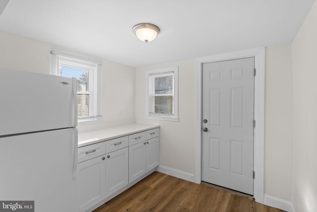 interior space with white cabinets, dark hardwood / wood-style flooring, and white fridge